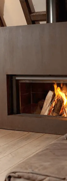 Photo d'une cheminée avec un chat couché devant.